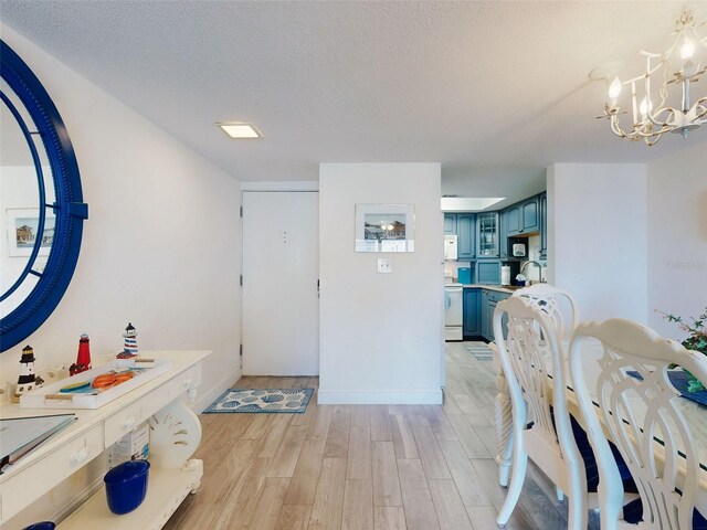 4175 S Atlantic Ave Unit 4110, New Smyrna Beach, FL 32169 - entryway featuring light wood finished floors, a chandelier, and a textured ceiling