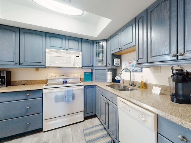 4175 S Atlantic Ave Unit 4110, New Smyrna Beach, FL 32169 - kitchen featuring white appliances, blue cabinets, glass insert cabinets, a raised ceiling, and light wood-type flooring
