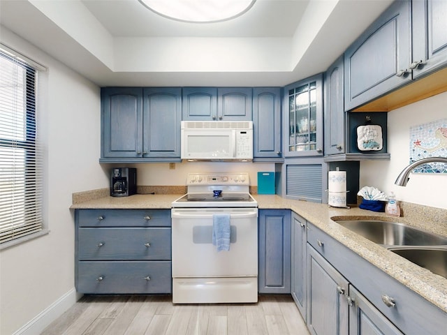4175 S Atlantic Ave Unit 4110, New Smyrna Beach, FL 32169 - kitchen with white appliances, a tray ceiling, light wood finished floors, glass insert cabinets, and blue cabinetry