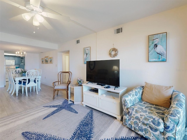 4175 S Atlantic Ave Unit 4110, New Smyrna Beach, FL 32169 - living area featuring a chandelier, ceiling fan, and wood finished floors