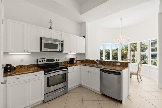 2 Oceans W Blvd Unit 206, Daytona Beach Shores, FL 32118 - kitchen featuring appliances with stainless steel finishes, white cabinets, and light tile patterned floors