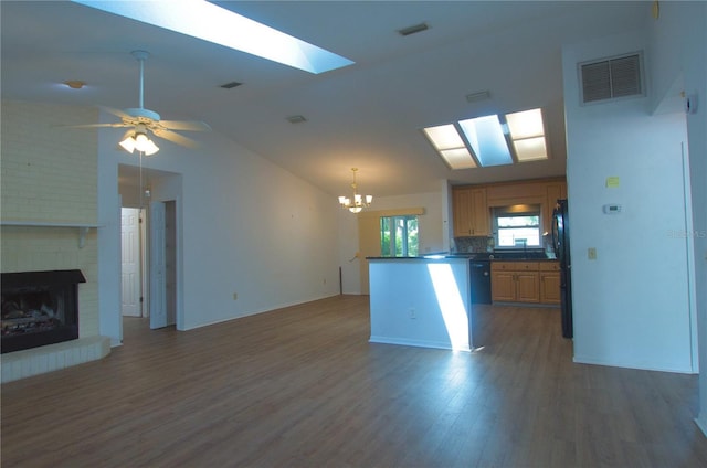 2548 Crestwood Ave, New Smyrna Beach, FL 32168 - kitchen with a chandelier, wood finished floors, a skylight, vaulted ceiling, and freestanding refrigerator