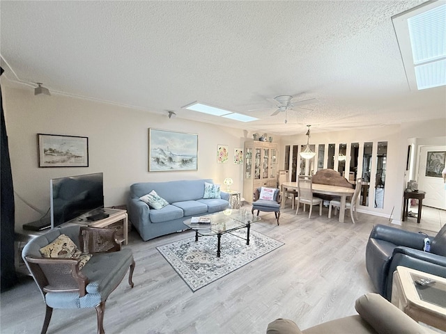 51 Fore Dr, New Smyrna Beach, FL 32168 - living area with a textured ceiling, light wood-style flooring, ceiling fan, and a skylight