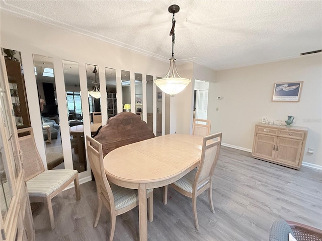 51 Fore Dr, New Smyrna Beach, FL 32168 - dining area featuring a textured ceiling, light wood-style flooring, and crown molding