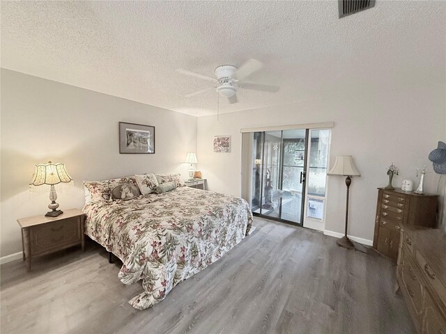 51 Fore Dr, New Smyrna Beach, FL 32168 - bedroom featuring access to exterior, wood finished floors, a textured ceiling, and a ceiling fan