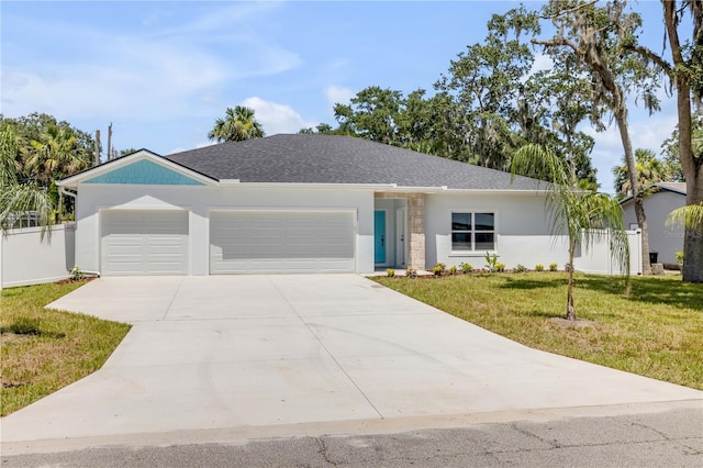 2324 Orange Tree Dr, Edgewater, FL 32141 - view of front of property with a garage, a front yard, concrete driveway, stucco siding, and roof with shingles