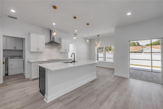 2324 Orange Tree Dr, Edgewater, FL 32141 - kitchen featuring washer / dryer, wall chimney range hood, black electric cooktop, light wood-style flooring, and recessed lighting