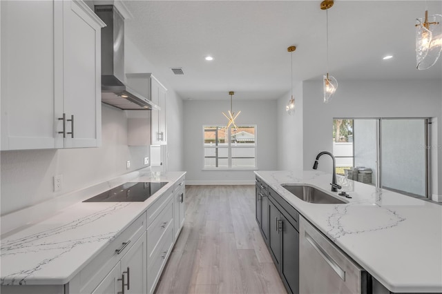 2324 Orange Tree Dr, Edgewater, FL 32141 - kitchen with black electric stovetop, wall chimney exhaust hood, stainless steel dishwasher, light wood-type flooring, and a center island with sink