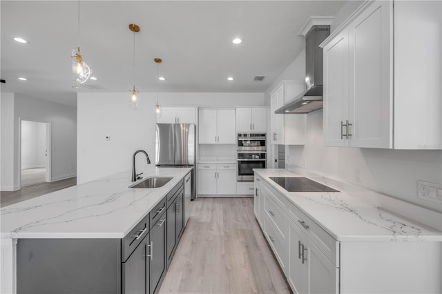 2324 Orange Tree Dr, Edgewater, FL 32141 - kitchen with wall chimney exhaust hood, black electric cooktop, light wood-style floors, recessed lighting, and white cabinetry