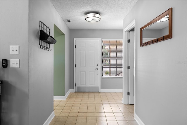 684 Rochester Ct, New Smyrna Beach, FL 32168 - entryway featuring light tile patterned floors and a textured ceiling