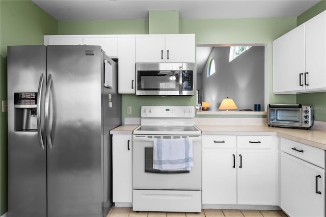 684 Rochester Ct, New Smyrna Beach, FL 32168 - kitchen featuring stainless steel appliances, light countertops, white cabinetry, and light tile patterned flooring