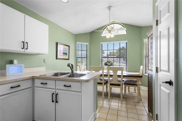 684 Rochester Ct, New Smyrna Beach, FL 32168 - kitchen featuring a peninsula, lofted ceiling, ceiling fan, light countertops, and white cabinets