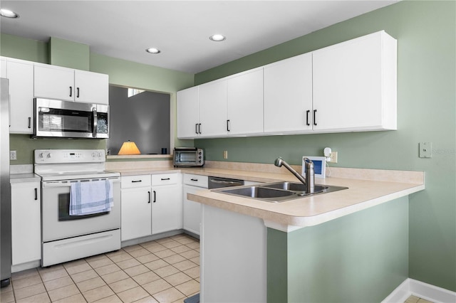 684 Rochester Ct, New Smyrna Beach, FL 32168 - kitchen featuring stainless steel appliances, light countertops, a peninsula, recessed lighting, and light tile patterned flooring