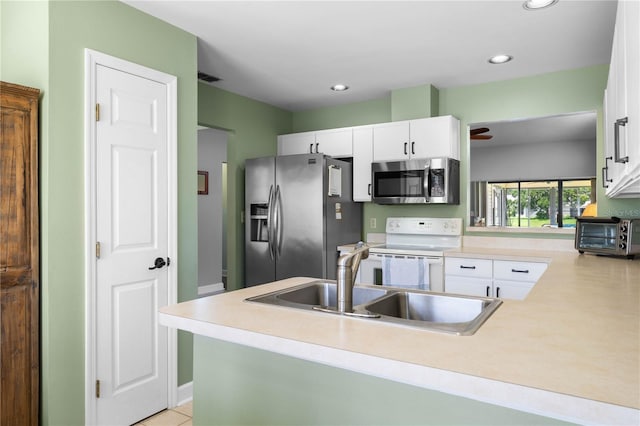 684 Rochester Ct, New Smyrna Beach, FL 32168 - kitchen with appliances with stainless steel finishes, white cabinets, light countertops, recessed lighting, and a peninsula