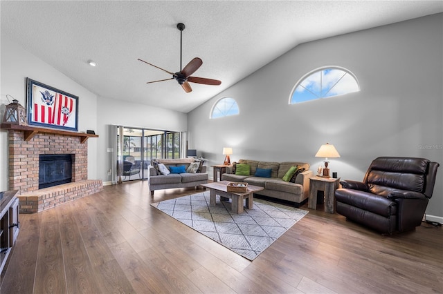 684 Rochester Ct, New Smyrna Beach, FL 32168 - living room with ceiling fan, wood finished floors, a textured ceiling, high vaulted ceiling, and a brick fireplace