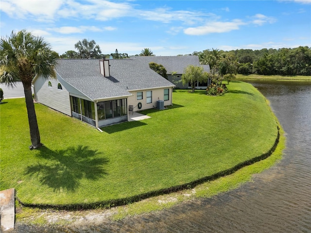 684 Rochester Ct, New Smyrna Beach, FL 32168 - back of house featuring a sunroom, a water view, a chimney, a lawn, and a shingled roof