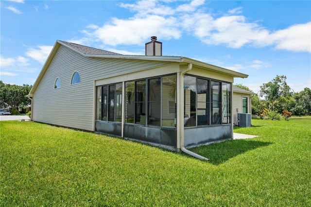 684 Rochester Ct, New Smyrna Beach, FL 32168 - back of house with a chimney, a sunroom, and a lawn