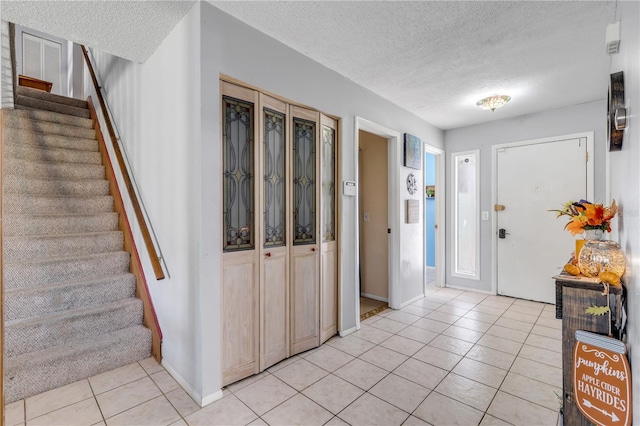 2715 Pine Tree Dr, Edgewater, FL 32141 - foyer entrance featuring light tile patterned floors, a textured ceiling, and stairway
