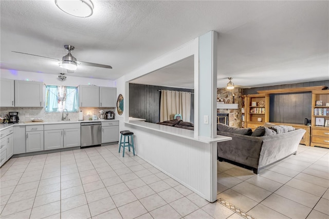 2715 Pine Tree Dr, Edgewater, FL 32141 - kitchen with dishwasher, a ceiling fan, open floor plan, light countertops, and a textured ceiling