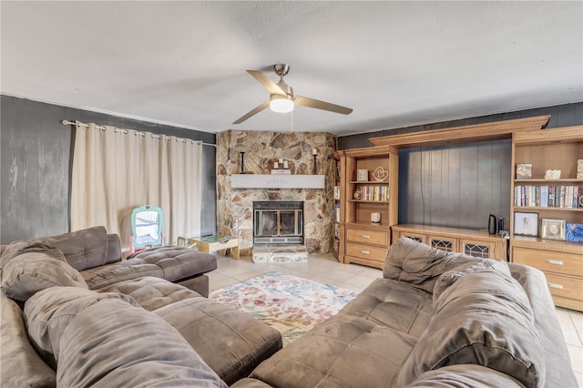 2715 Pine Tree Dr, Edgewater, FL 32141 - living room with ceiling fan, light tile patterned floors, wooden walls, and a stone fireplace