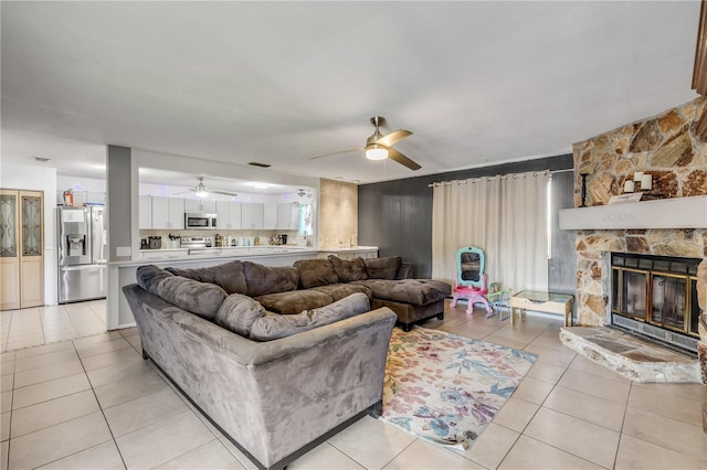 2715 Pine Tree Dr, Edgewater, FL 32141 - living area featuring light tile patterned floors, ceiling fan, and a fireplace