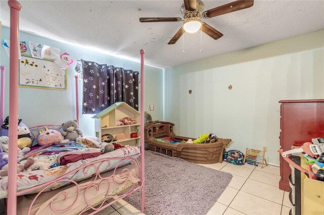 2715 Pine Tree Dr, Edgewater, FL 32141 - bedroom featuring tile patterned floors, ceiling fan, and a textured ceiling