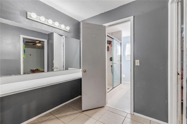 2715 Pine Tree Dr, Edgewater, FL 32141 - full bath featuring a ceiling fan, tile patterned flooring, a stall shower, and a textured wall