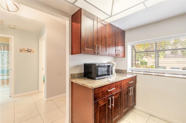 1237 Charter Oaks Cir, Daytona Beach, FL 32117 - kitchen with stainless steel microwave, light stone counters, and light tile patterned flooring