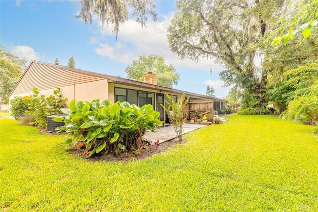 1237 Charter Oaks Cir, Daytona Beach, FL 32117 - view of grassy yard featuring a patio area and a sunroom