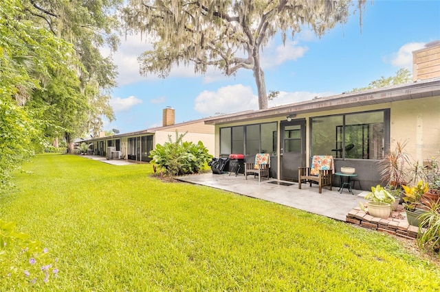1237 Charter Oaks Cir, Daytona Beach, FL 32117 - back of house with a chimney, a patio, a lawn, and stucco siding