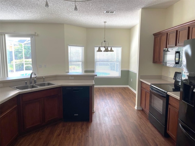 405 Central Mariners Dr, Edgewater, FL 32141 - kitchen with black appliances, dark wood-style flooring, light countertops, a textured ceiling, and pendant lighting