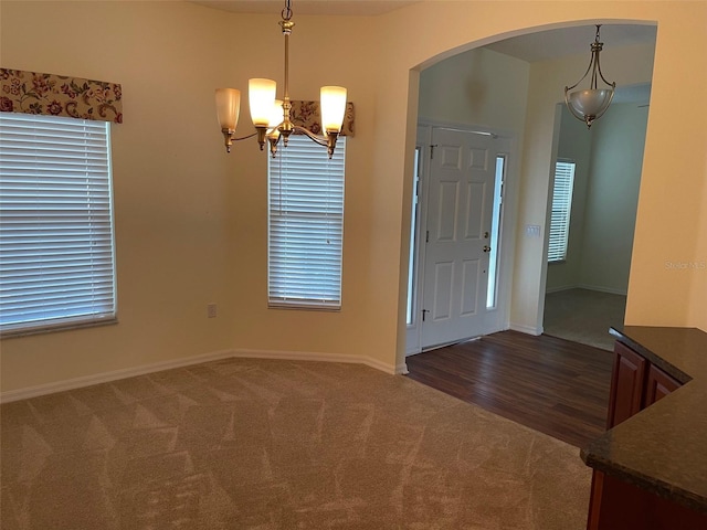 405 Central Mariners Dr, Edgewater, FL 32141 - foyer with arched walkways, dark carpet, and a chandelier