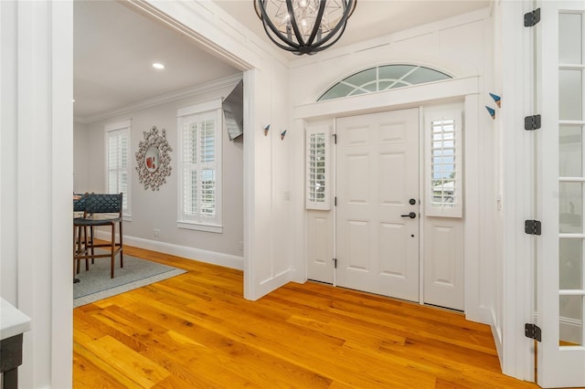 1212 S Riverside Dr, New Smyrna Beach, FL 32168 - entrance foyer with crown molding, light wood-style floors, a chandelier, and recessed lighting
