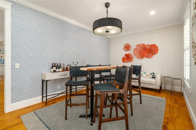 1212 S Riverside Dr, New Smyrna Beach, FL 32168 - dining space with an accent wall, crown molding, and wood finished floors