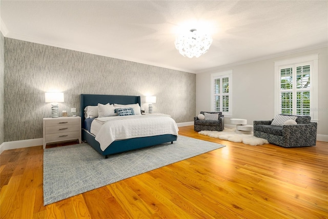 1212 S Riverside Dr, New Smyrna Beach, FL 32168 - bedroom with wallpapered walls, a chandelier, wood finished floors, crown molding, and an accent wall