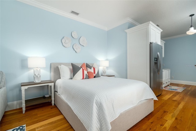 1212 S Riverside Dr, New Smyrna Beach, FL 32168 - bedroom featuring stainless steel refrigerator with ice dispenser, crown molding, and light wood finished floors