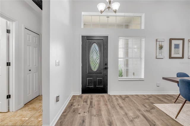 5849 Ansley Way, Mount Dora, FL 32757 - foyer featuring a towering ceiling, wood finished floors, and a chandelier