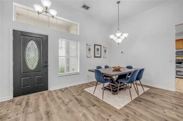 5849 Ansley Way, Mount Dora, FL 32757 - dining space featuring a chandelier, ornamental molding, light wood-type flooring, and a towering ceiling