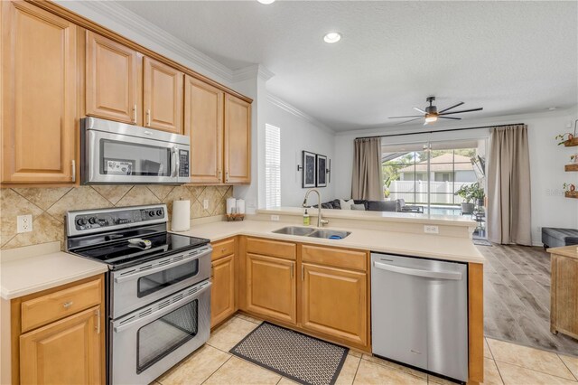 5849 Ansley Way, Mount Dora, FL 32757 - kitchen featuring stainless steel appliances, a peninsula, open floor plan, decorative backsplash, and a ceiling fan