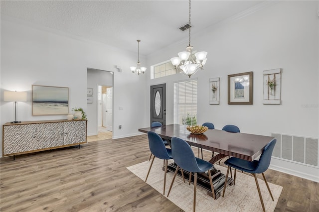 5849 Ansley Way, Mount Dora, FL 32757 - dining room with a chandelier, wood finished floors, ornamental molding, and a high ceiling