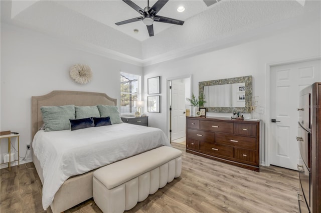 5849 Ansley Way, Mount Dora, FL 32757 - bedroom featuring light wood-type flooring, refrigerator, a raised ceiling, and ceiling fan