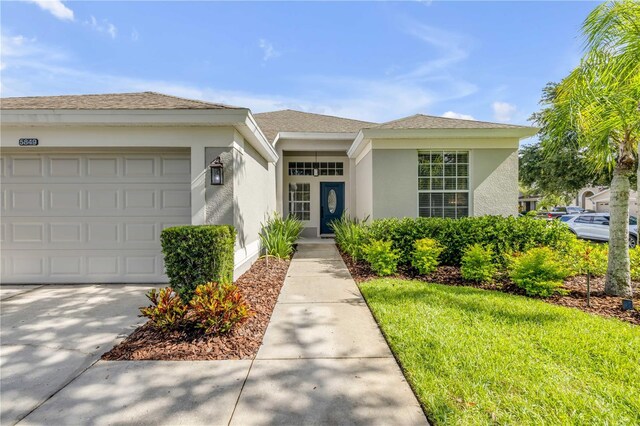 5849 Ansley Way, Mount Dora, FL 32757 - view of front of property with stucco siding, an attached garage, and driveway