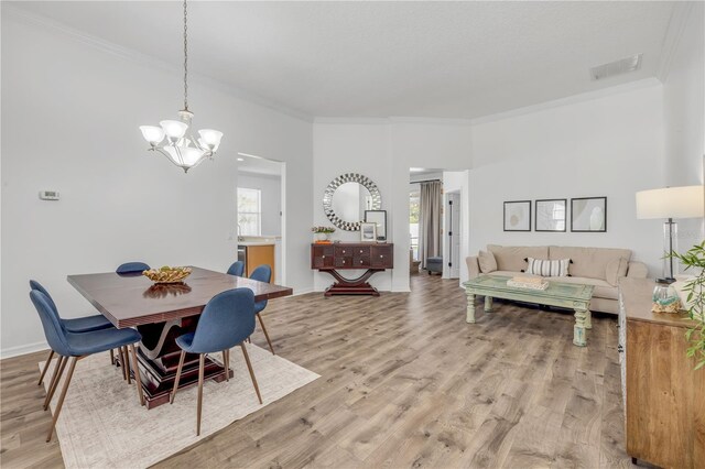 5849 Ansley Way, Mount Dora, FL 32757 - dining area with ornamental molding, a chandelier, and light wood-style floors