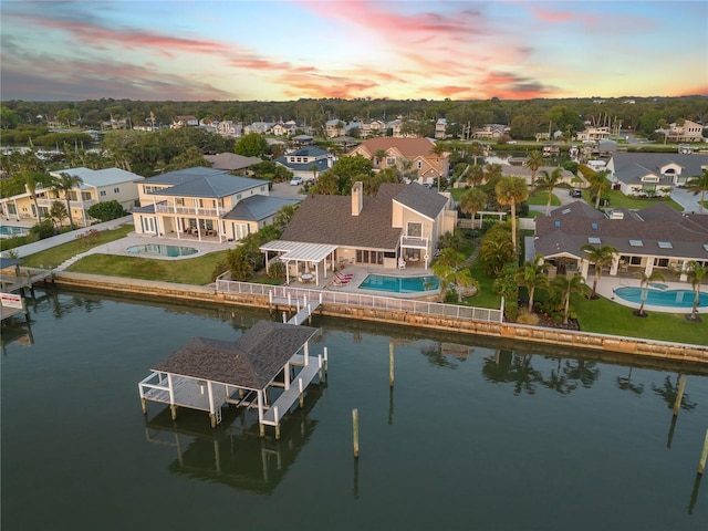 1219 Commodore Dr, New Smyrna Beach, FL 32168 - aerial view at dusk of a residential view, view of pool area, and a water view