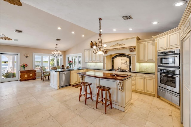 1219 Commodore Dr, New Smyrna Beach, FL 32168 - kitchen featuring cream cabinetry, a warming drawer, appliances with stainless steel finishes, a chandelier, and recessed lighting