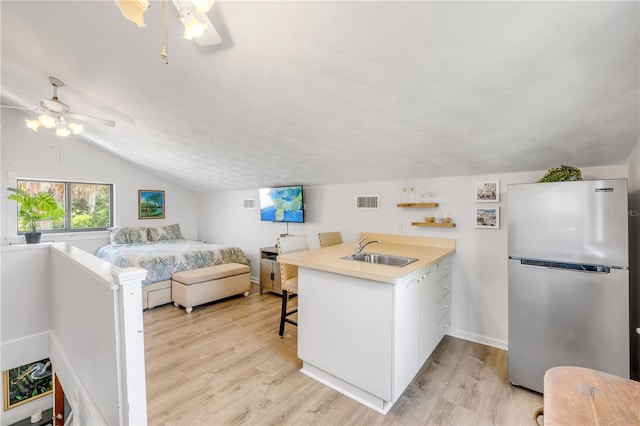 1219 Commodore Dr, New Smyrna Beach, FL 32168 - bedroom featuring freestanding refrigerator, lofted ceiling, light wood-style flooring, and ceiling fan