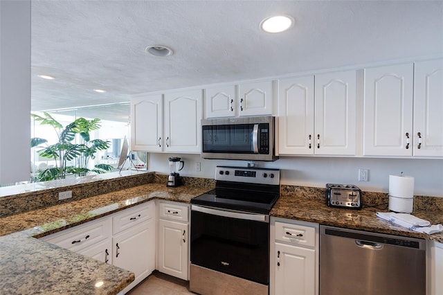 1051 Ocean Shore Blvd Unit 502, Ormond Beach, FL 32176 - kitchen featuring stainless steel appliances, white cabinets, dark stone counters, and recessed lighting