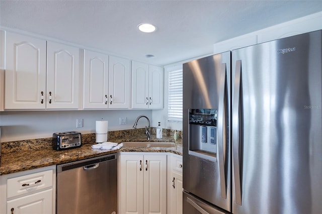 1051 Ocean Shore Blvd Unit 502, Ormond Beach, FL 32176 - kitchen featuring stainless steel appliances, white cabinetry, and dark stone countertops