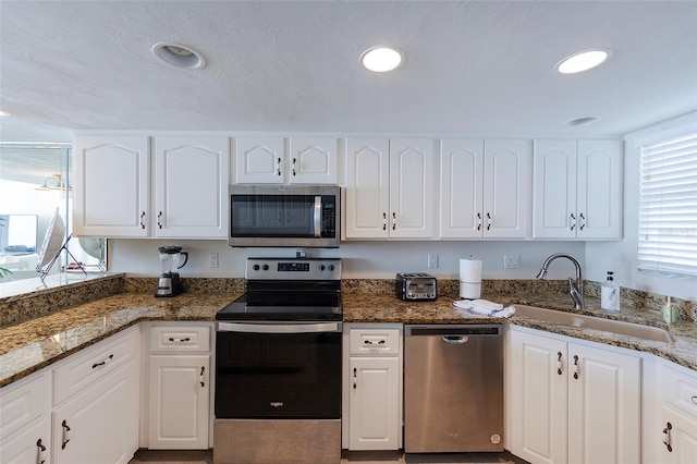 1051 Ocean Shore Blvd Unit 502, Ormond Beach, FL 32176 - kitchen featuring stainless steel appliances, white cabinets, stone counters, and recessed lighting