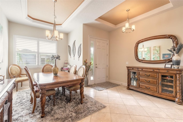 2939 Bella Flore Ter, New Smyrna Beach, FL 32168 - dining area with a tray ceiling, a chandelier, and light tile patterned floors